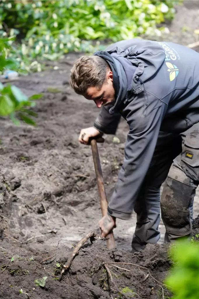 man graaft gat, eigenaar van Happy Gardens.