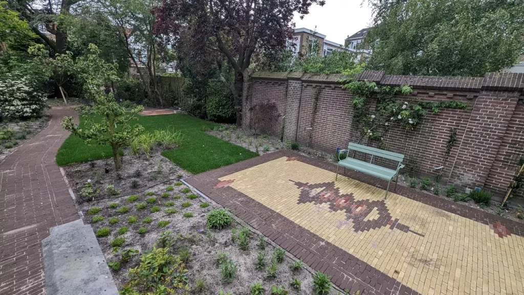 Hovenier plaatst nieuwe tegels voor een tuinpad.